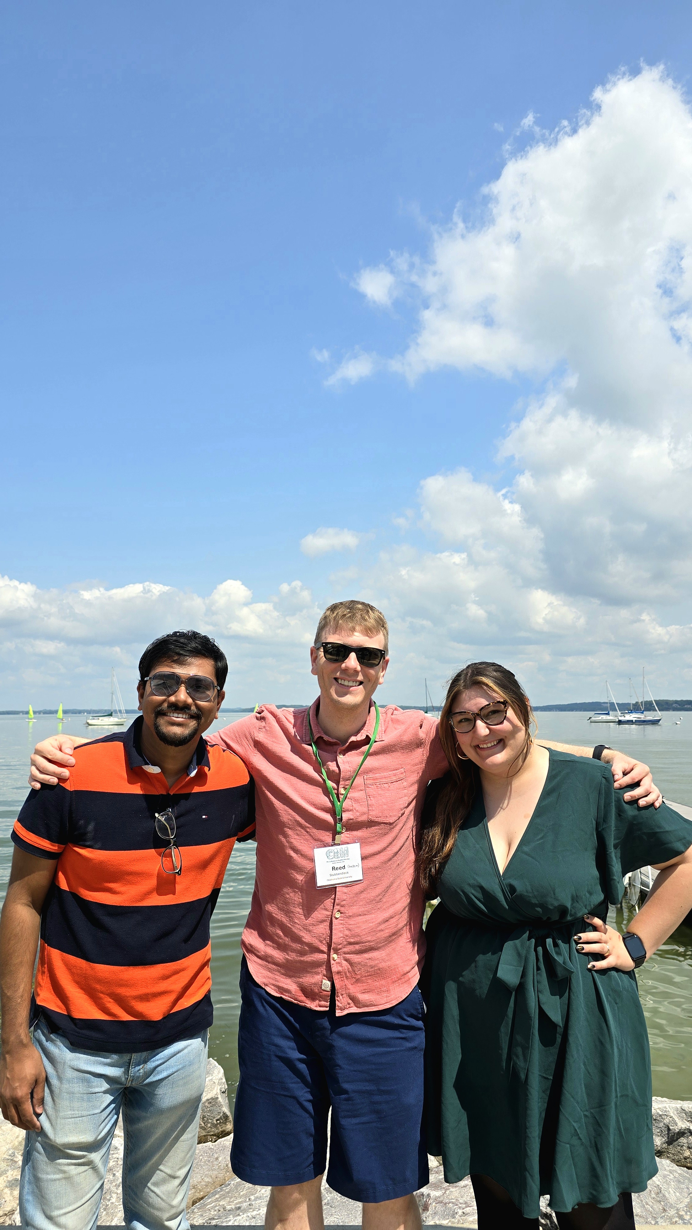 Photograph of Niladri, Reed, and Madeline standing in front of Lake Mendota in Madison, WI.